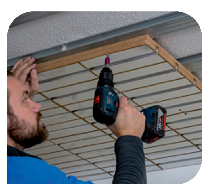 Installer completing a room-by-room ceiling heating retrofit in a residential property